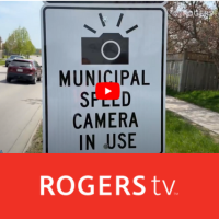 Sign stating Municipal Speed Camera in Use with RogersTV  and the youtube symbol in the middle